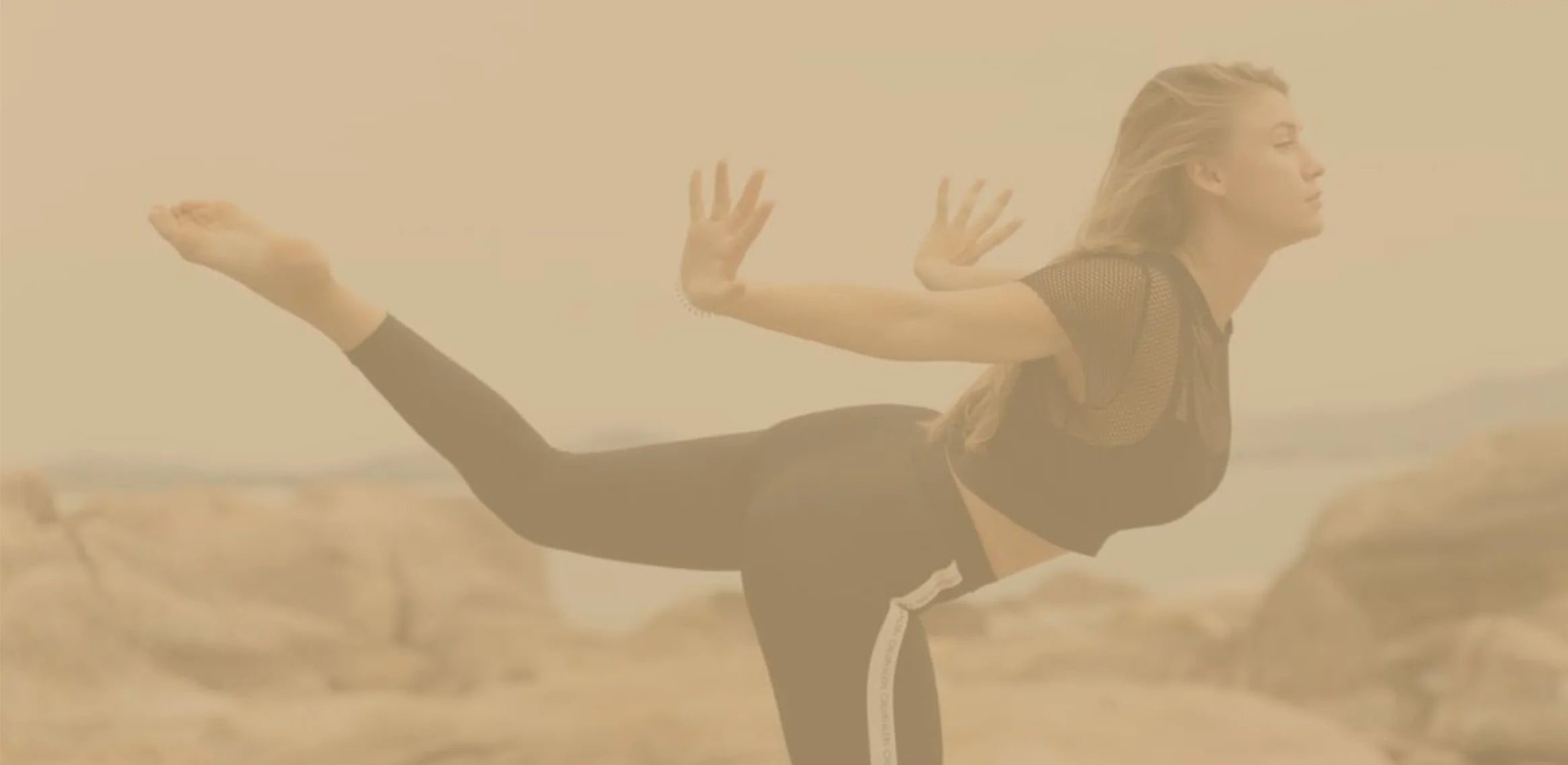 Person practicing yoga on a beach with a hazy background