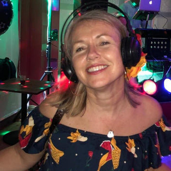 Woman wearing headphones in a colorful, possibly karaoke setting