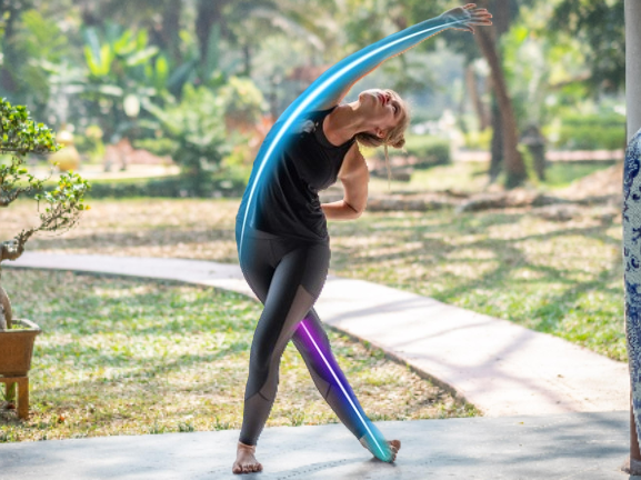 Person stretching with a colorful yoga strap outdoors